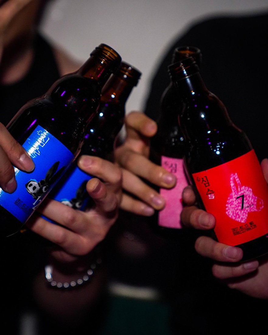 Guests raising Simsool bottles at an *82 party night