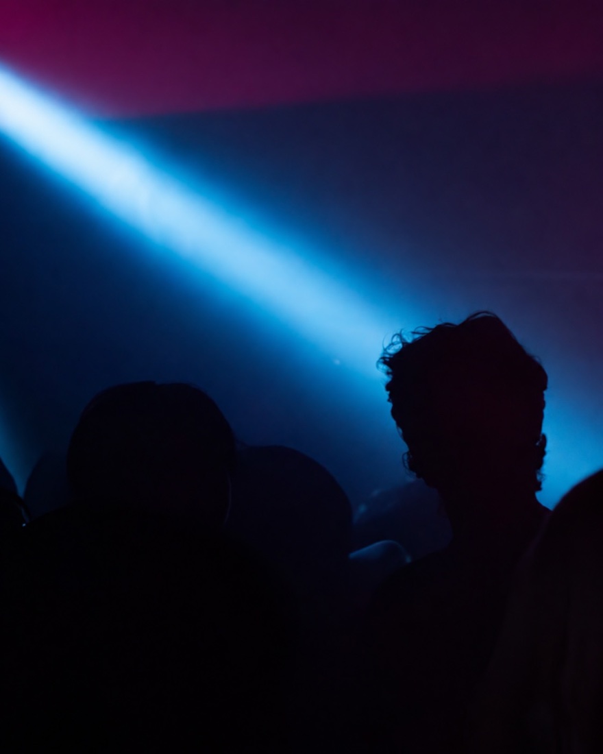 Light beam cutting through the crowd at *82 party